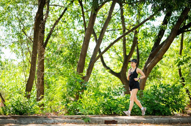 mujer asiática hermosa de mediana edad caminando al aire libre en el parque sonriendo viviendo un estilo de vida activo y saludable.