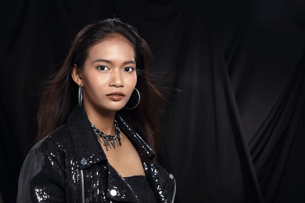 Mujer asiática hermosa piel bronceada con moda maquillaje cabello negro, fondo de tela oscura de iluminación de estudio, retrato de medio cuerpo en la cabeza. chaqueta de lentejuelas negra, concepto de lujo para unirse al evento social nocturno