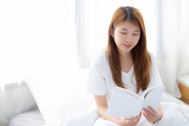 La mujer asiática hermosa relaja sentarse leyendo el libro