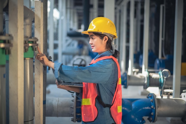 Mujer asiática ingeniera usando computadora trabajando en fábrica