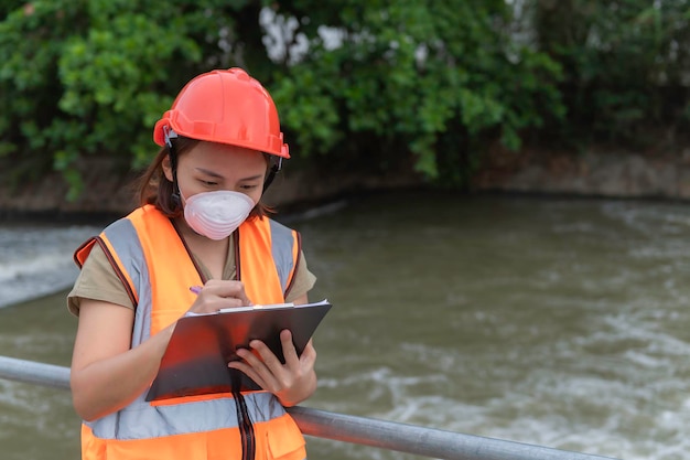 Mujer asiática ingeniería trabajando xA en la planta de tratamiento de aguas residualesBiólogo marino analizando los resultados de las pruebas de aguaConcepto del día mundial del medio ambiente
