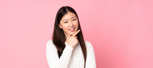 Mujer asiática joven en aislado feliz y sonriente