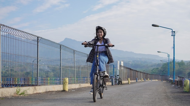 Mujer asiática joven andar en bicicleta al trabajo ella es feliz y segura