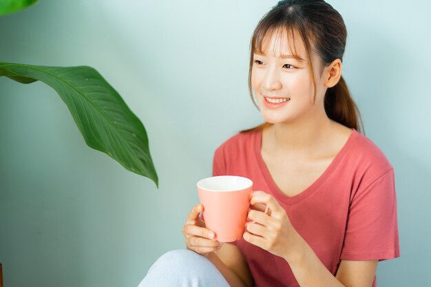 Mujer asiática joven beber café por la mañana