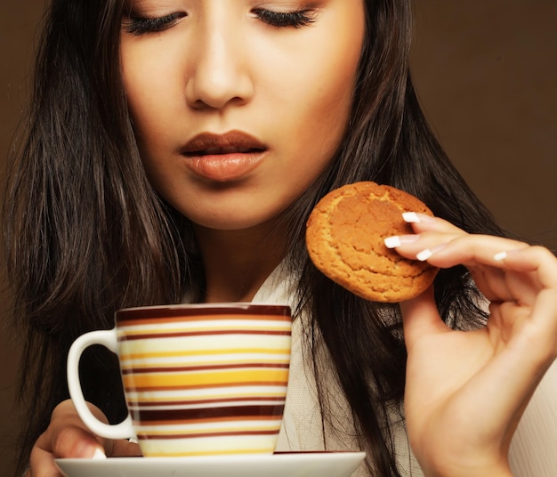 Mujer asiática joven con café y galletas.