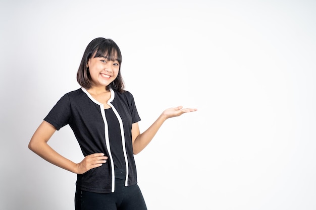 Mujer asiática joven con gesto de la mano que presenta algo