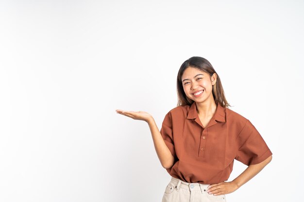 Mujer asiática joven con gesto de la mano que presenta algo