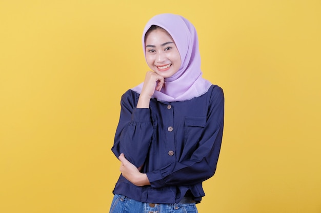 Foto la mujer asiática joven que es positiva con una sonrisa alegre en la cara que lleva un hijab y ropa casual en la habitación es amarilla.