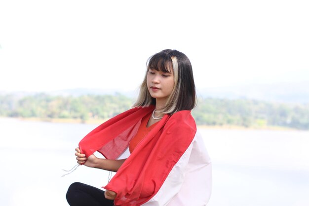 Foto mujer asiática joven que lleva la bandera indonesia