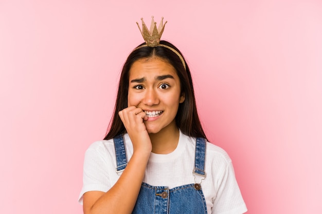 La mujer asiática joven que llevaba una corona aisló morderse las uñas, nervioso y muy ansioso.