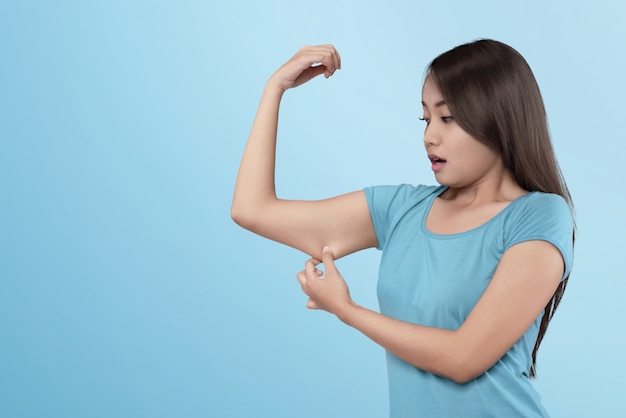 Foto mujer asiática joven que pierde el músculo en su brazo