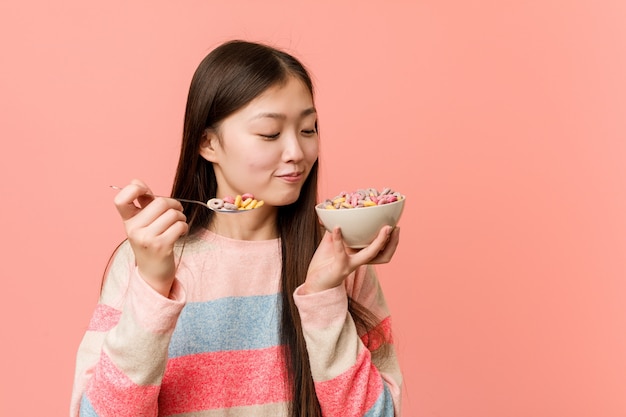 Mujer asiática joven que sostiene un tazón de cereal