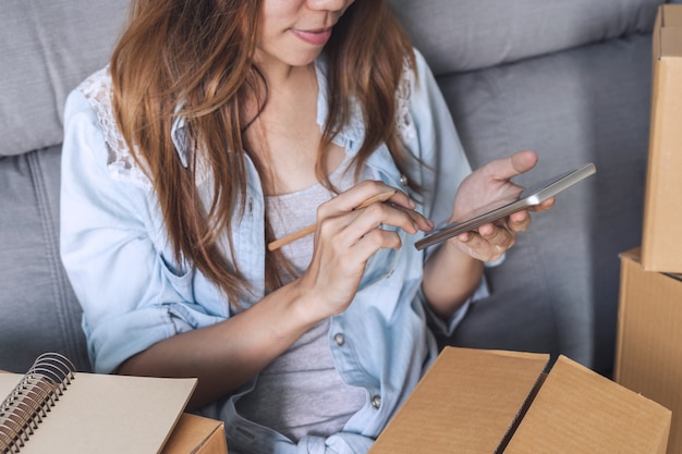 Foto mujer asiática joven que trabaja negocio en línea usando el teléfono elegante