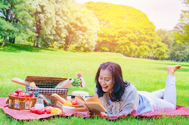 La mujer asiática joven relaja tiempo en parque