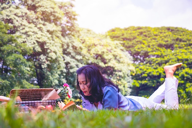 La mujer asiática joven relaja tiempo en parque