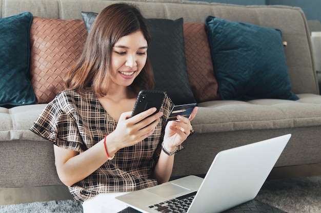 Foto mujer asiática joven con tarjeta de crédito para compras en línea