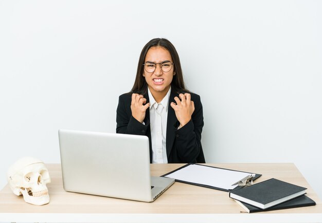 Mujer asiática joven traumatólogo molesto gritando con las manos tensas.