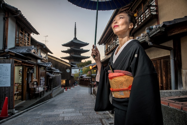 Mujer asiática con kimono caminando en la pagoda de Yasaka en Kioto