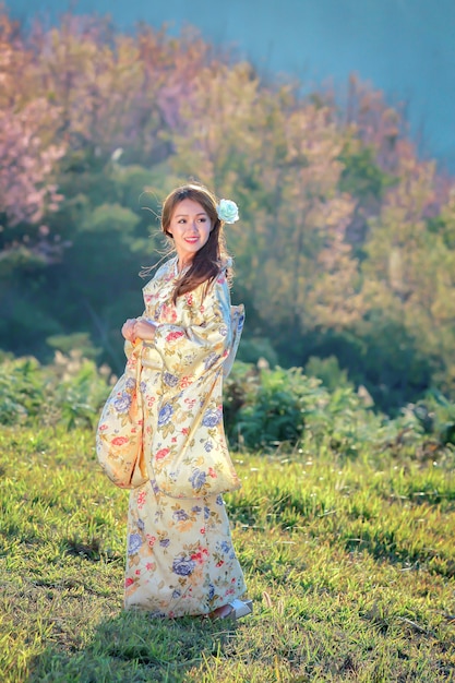 Mujer asiática con kimono tradicional japonés en el jardín de sakura.