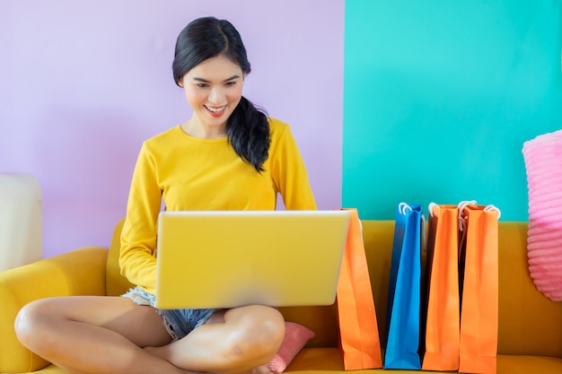 Mujer asiática con laptop de compras en línea