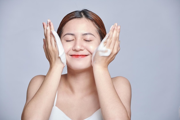 Mujer asiática lavado de rostro exfoliación fregado jabón Asia chica lavado fregado con espuma cuidado de la piel