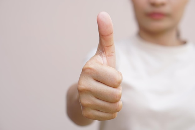 Mujer asiática levantando la mano mostrando gran señal