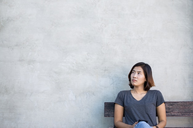 Foto la mujer asiática linda está pensando algo sobre fondo gris