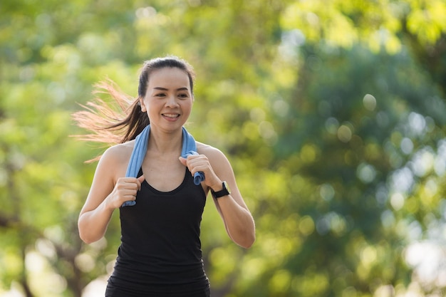 Una mujer asiática madura haciendo ejercicio de jogging en el parque de la ciudad