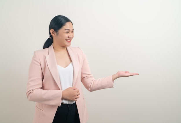 Mujer asiática con la mano presente en la pared blanca