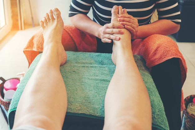 Mujer asiática con masaje tailandés tradicional en los pies