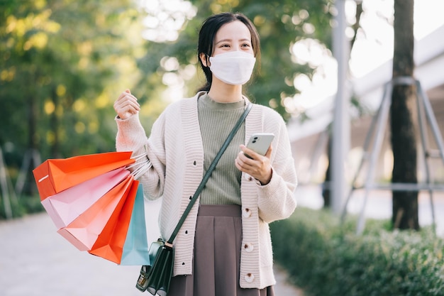 Mujer asiática con una máscara mientras camina por la calle