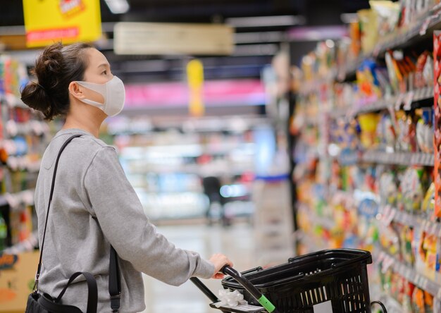 Mujer asiática con una máscara en el supermercado