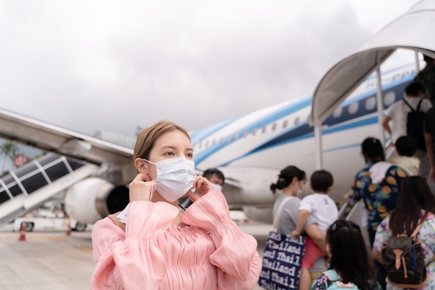 Mujer asiática con mascarilla protectora en avión