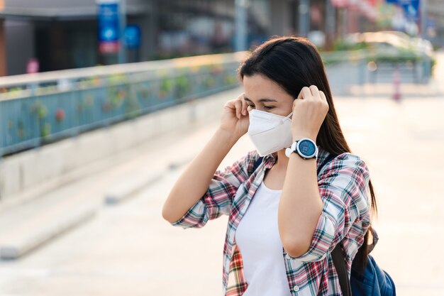 Foto mujer asiática con mascarilla para proteger del virus. concepto de coronavirus covid-19.