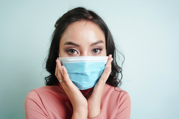 Foto mujer asiática con mascarilla quirúrgica para protegerse del virus covid-19 y la enfermedad