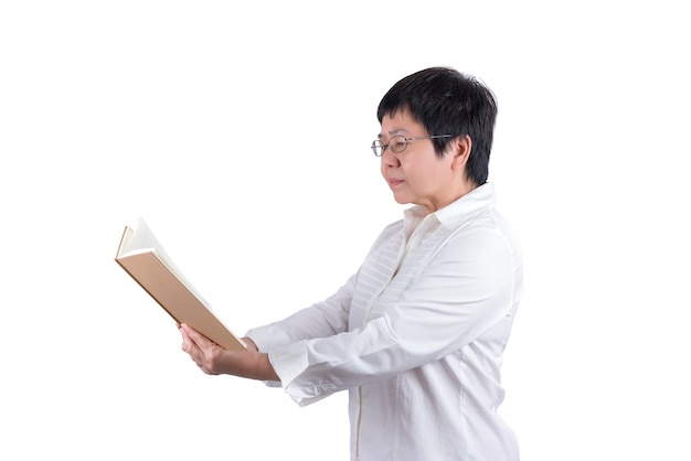 Foto mujer asiática de mediana edad en camisa blanca con anteojos leyendo un libro aislado sobre fondo blanco, concepto de vista