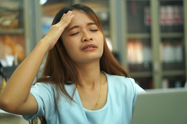 Mujer asiática mirando la computadora Frustrada por la disminución de las ganancias