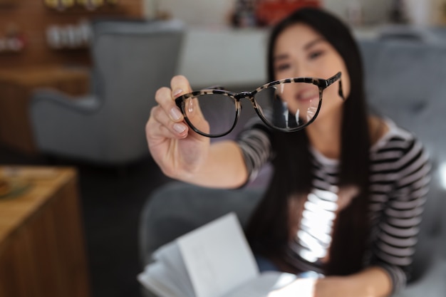 Foto mujer asiática mostrando anteojos