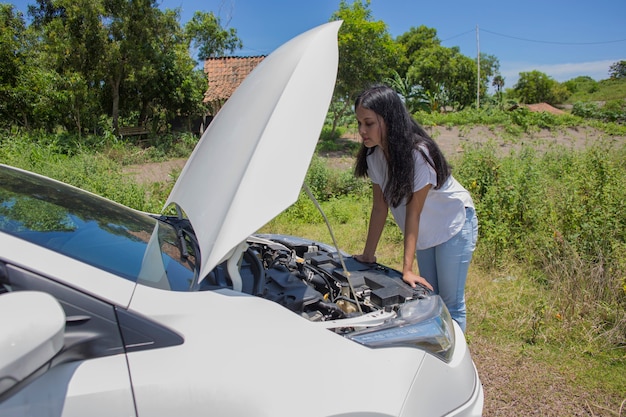 Foto mujer asiática necesita ayuda con un coche roto con capota abierta