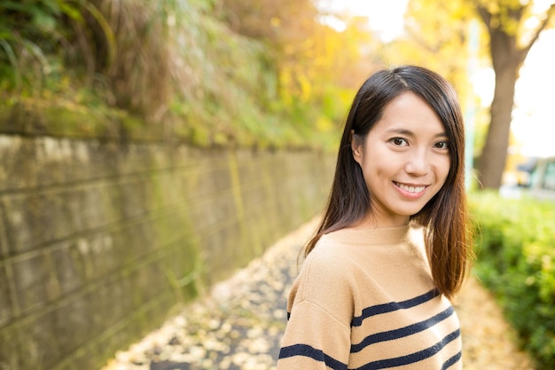 Mujer asiática en el parque con árbol de ginkgo