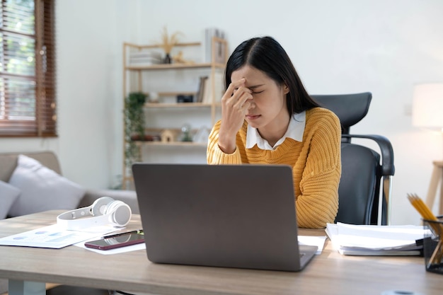 Mujer asiática pensando mucho preocupada por la solución de problemas en línea mirando la pantalla de la computadora portátil preocupada mujer de negocios asiática seria enfocada en resolver tareas difíciles de la computadora de trabajo