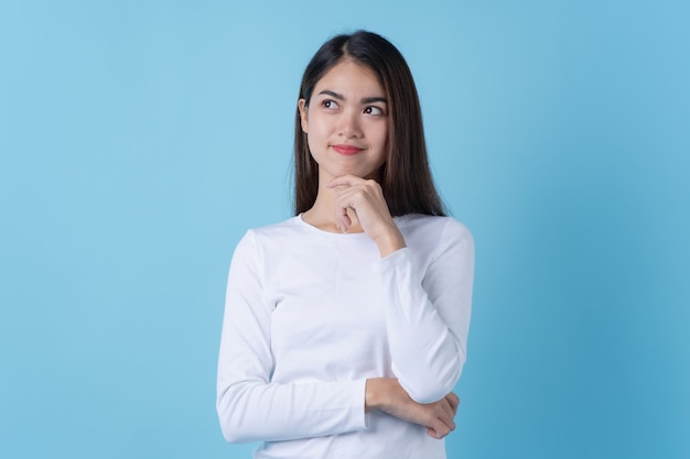 Mujer asiática pensando y sonriendo