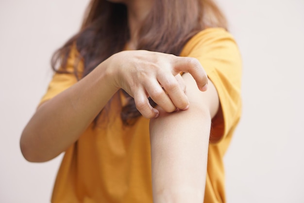 Mujer asiática con picazón en la piel del brazo