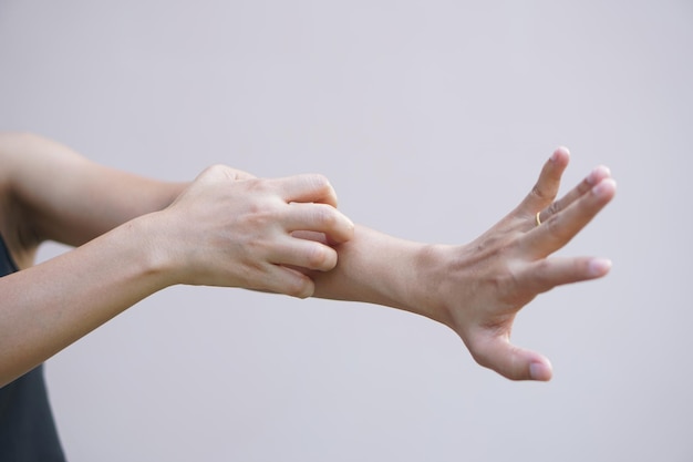 Mujer asiática con picazón en la piel del brazo