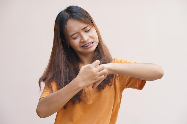 Mujer asiática con picazón en la piel de las manos