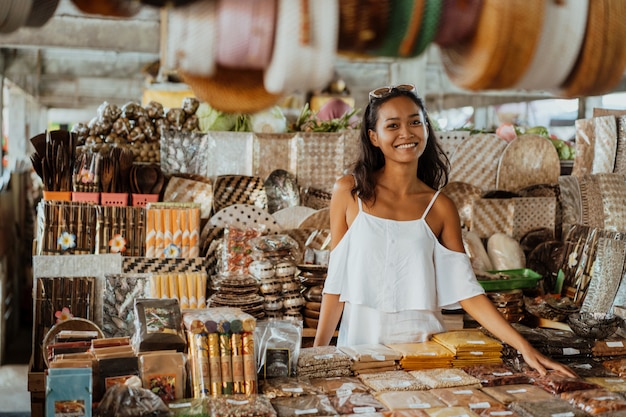 Mujer asiática con piel bronceada en la tienda de souvenirs