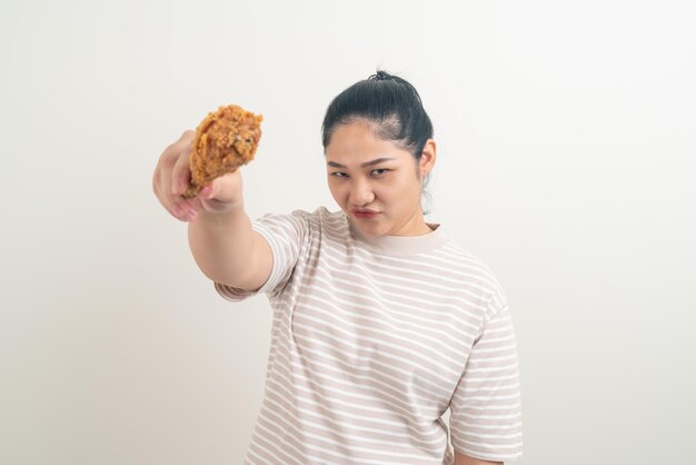 Mujer asiática con pollo frito a mano