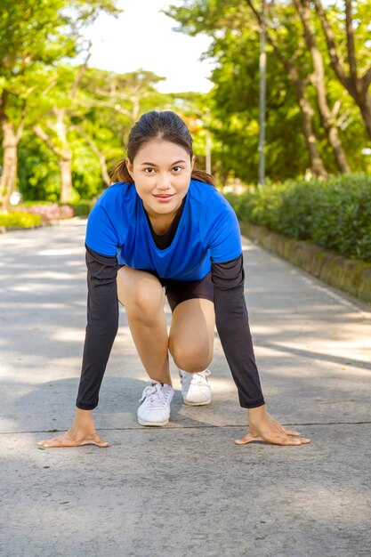 Mujer asiática en posición inicial lista para correr