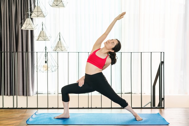 Mujer asiática practicando yoga desde casa cuando el brote de Covid19 y el encierro