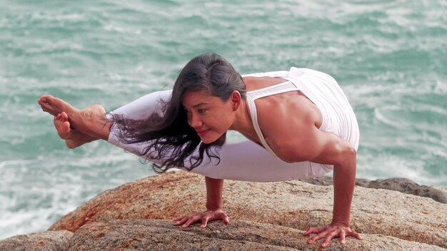 Mujer asiática practicando yoga pose Ashtavakrasana dedicado sabio Ashtavakra